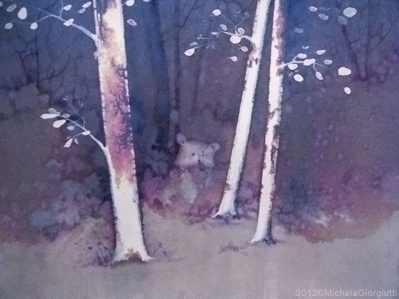 Un orso osserva da dietro un cespuglio tra gli alberi